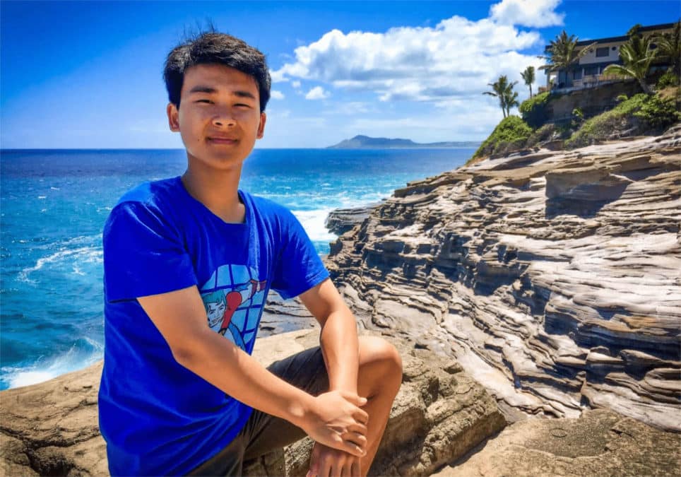 Dyson Chee standing on the rocky shores of Hawai’i