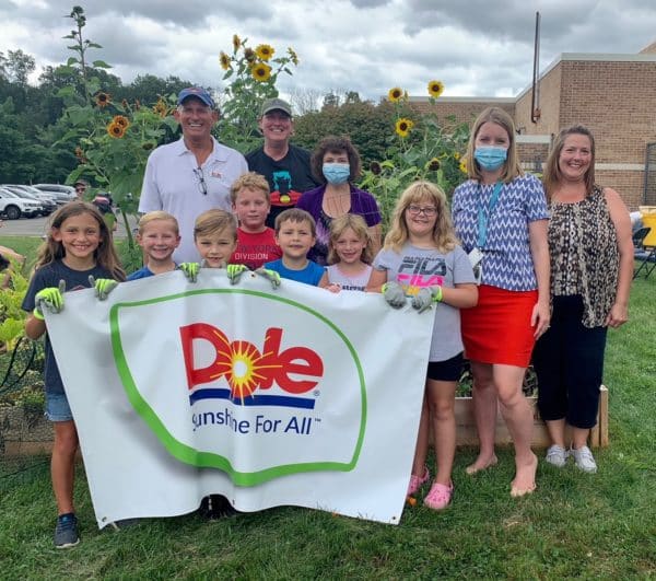 Students and teachers at Marlborough Elementary School hold a banner for the Dole garden