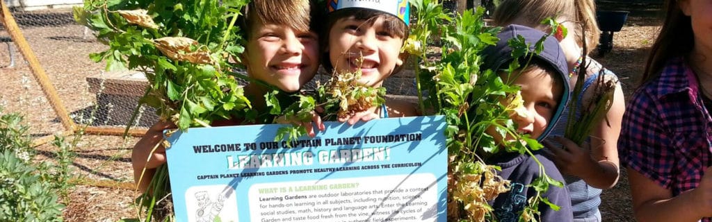 Young children holding Project Learning Garden sign