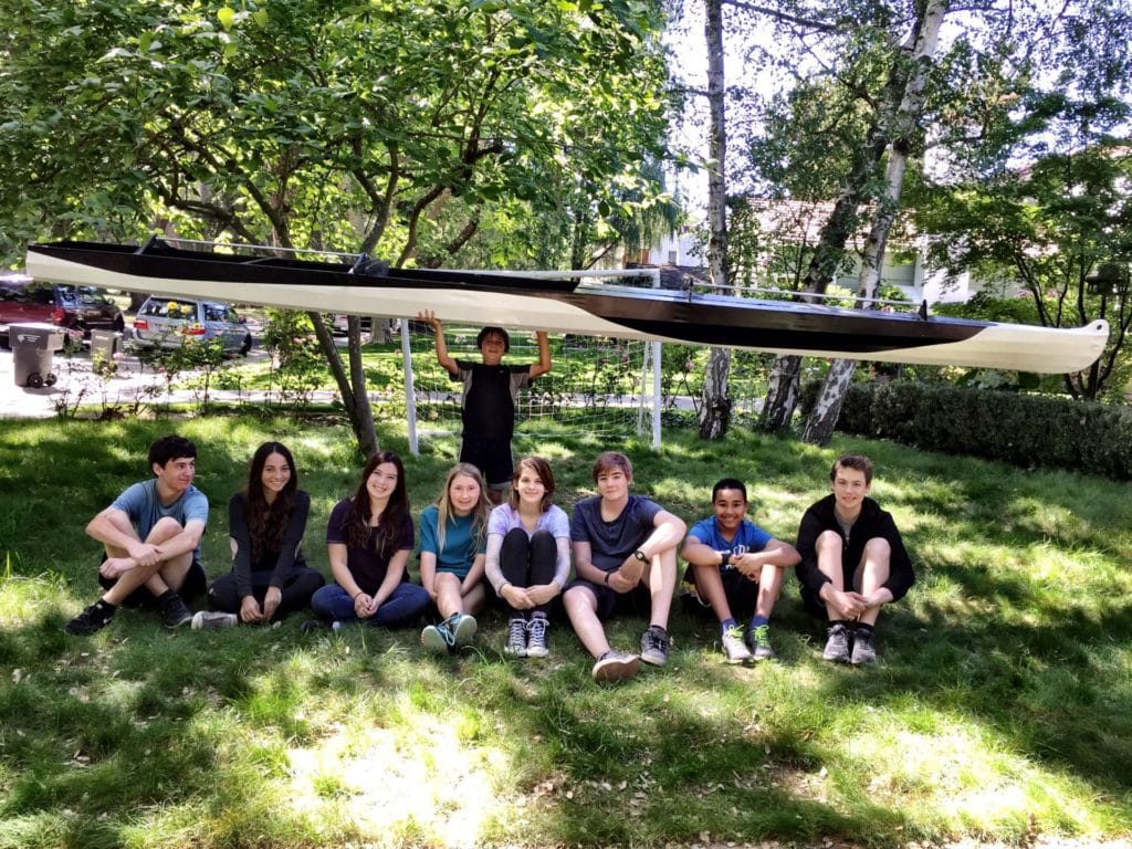 Students holding up kayak