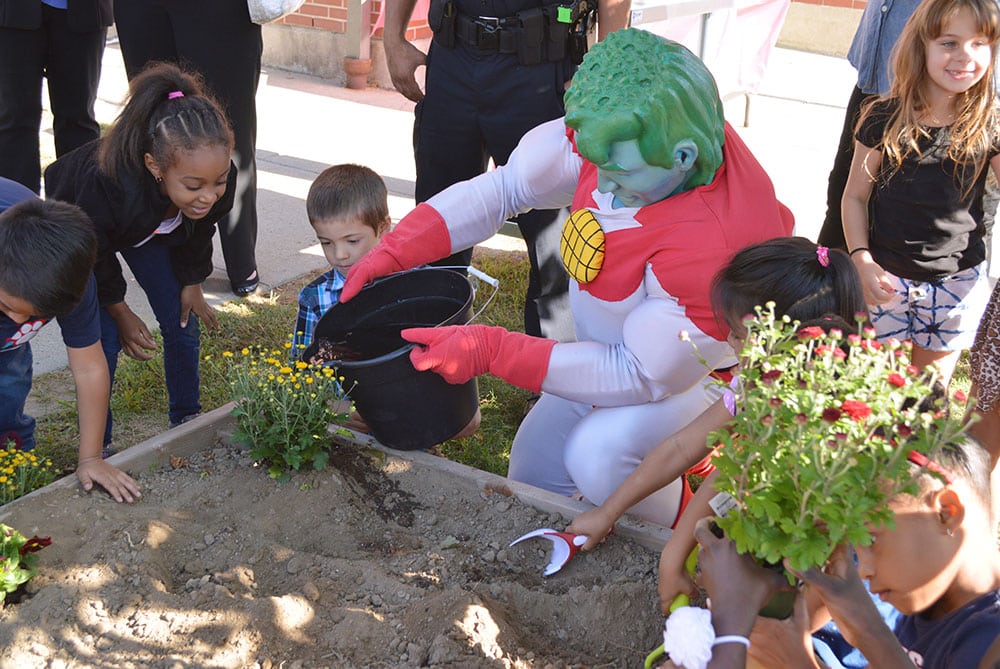 Captain Planet at Veazie Street Elementary garden installation planting pollinators in 2017, funded by Dole Packaged Food Company