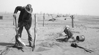 farmer shoveling dust off his field