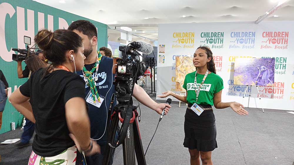 Maria Victória speaks with the media at the COP30 Children and Youth Major Group Pavillion.