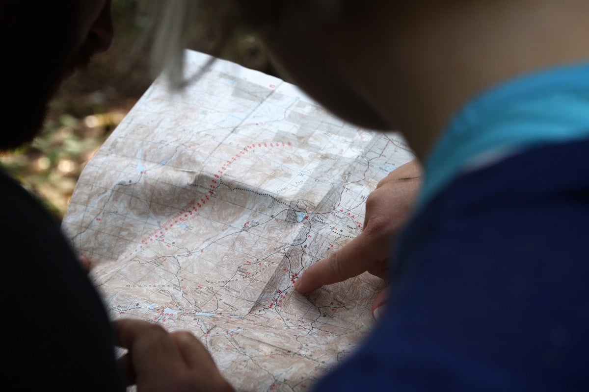 hand pointing to a location on a map