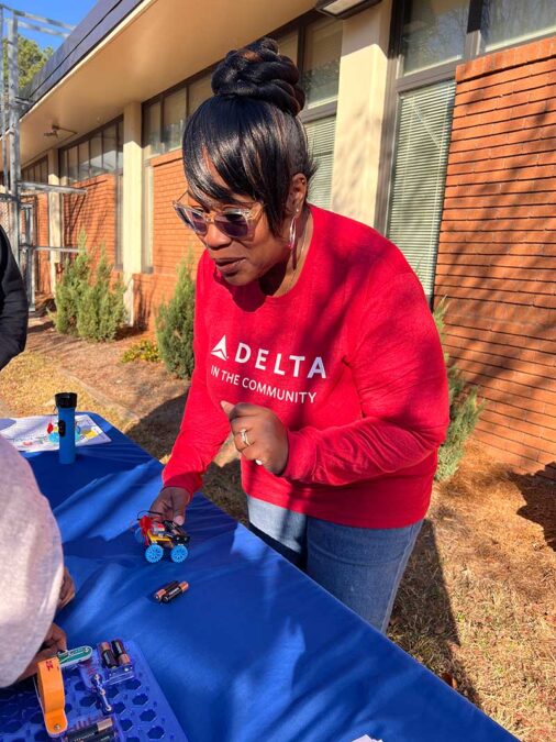 Delta Volunteer teaches students about solar-powered cars.