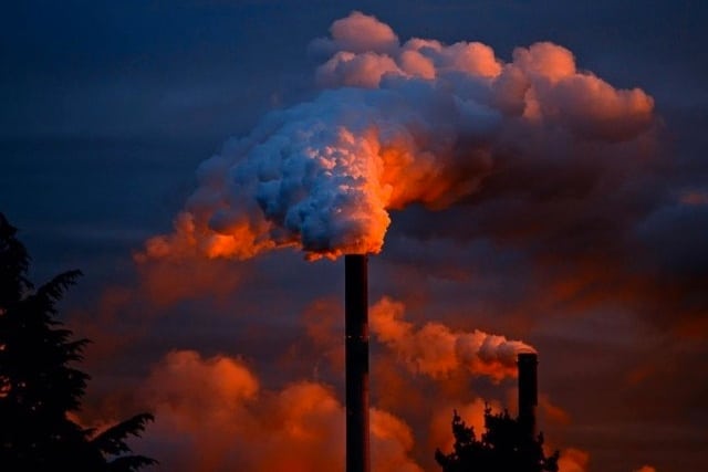 Smoke coming out of top of factory.