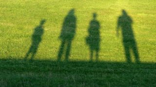 shadow of a family in the grass